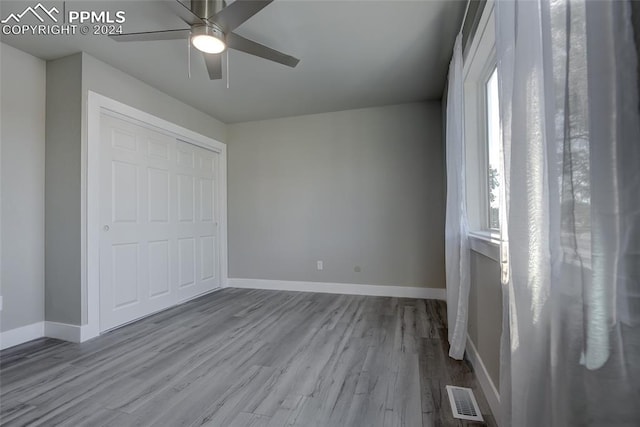 unfurnished bedroom featuring ceiling fan, light wood-type flooring, and a closet