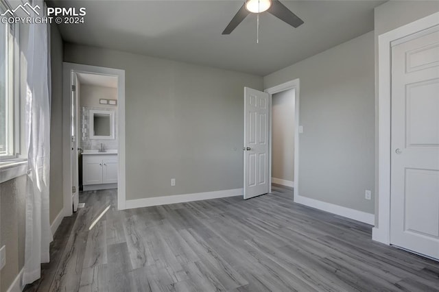 unfurnished bedroom featuring ceiling fan, light hardwood / wood-style flooring, ensuite bathroom, and sink