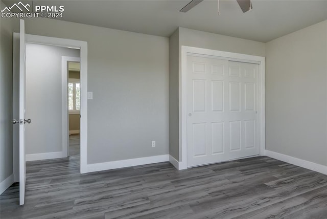 unfurnished bedroom featuring hardwood / wood-style floors, a closet, and ceiling fan