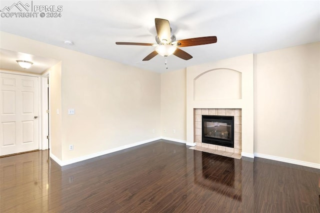 unfurnished living room featuring a fireplace, ceiling fan, and dark wood-type flooring