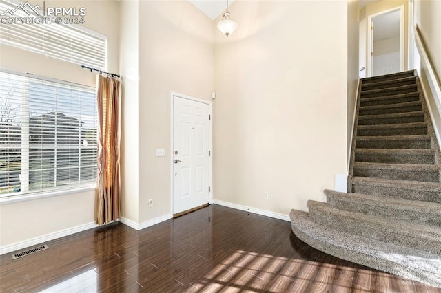 foyer with a high ceiling and dark hardwood / wood-style floors