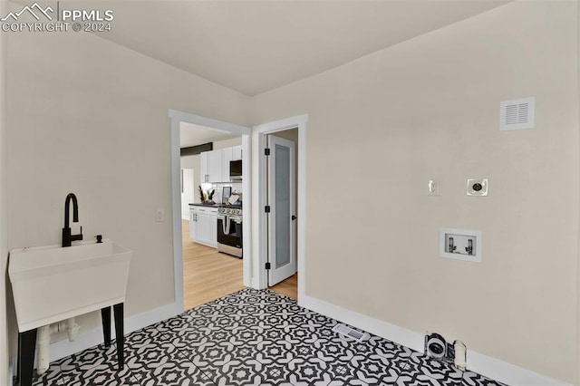 laundry area with washer hookup, hookup for an electric dryer, and light hardwood / wood-style flooring