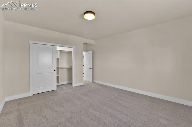 unfurnished bedroom with light carpet and a closet