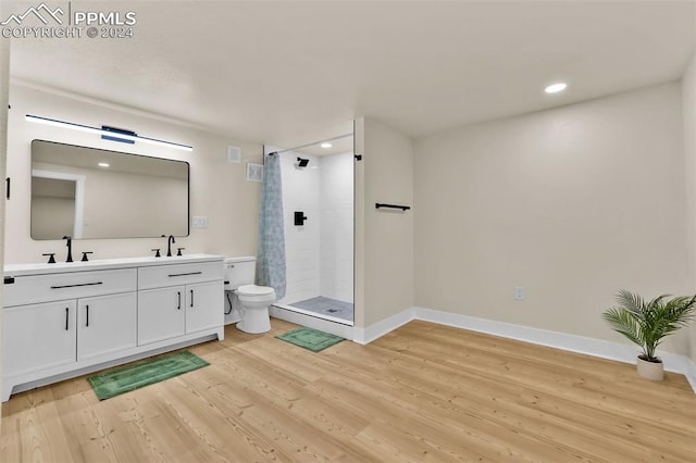 bathroom with hardwood / wood-style floors, vanity, toilet, and a shower with curtain