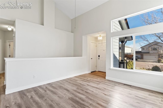 spare room featuring light hardwood / wood-style flooring and high vaulted ceiling