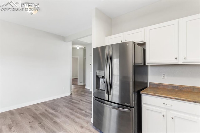 kitchen with white cabinetry, light wood-type flooring, and stainless steel refrigerator with ice dispenser