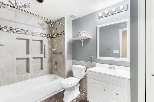 full bathroom featuring tile patterned floors, tiled shower / bath combo, toilet, and vanity