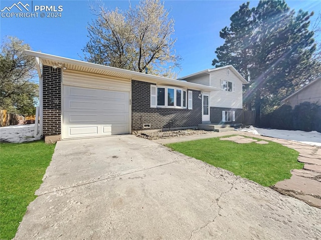 tri-level home with a garage and a front lawn