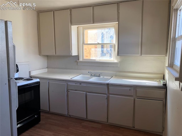 kitchen with sink, dark wood-type flooring, fridge, electric stove, and white cabinets