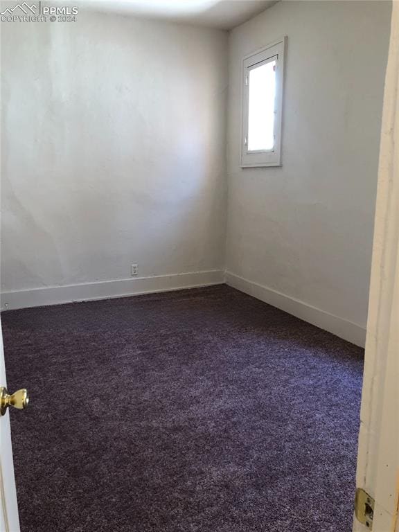 empty room with dark colored carpet