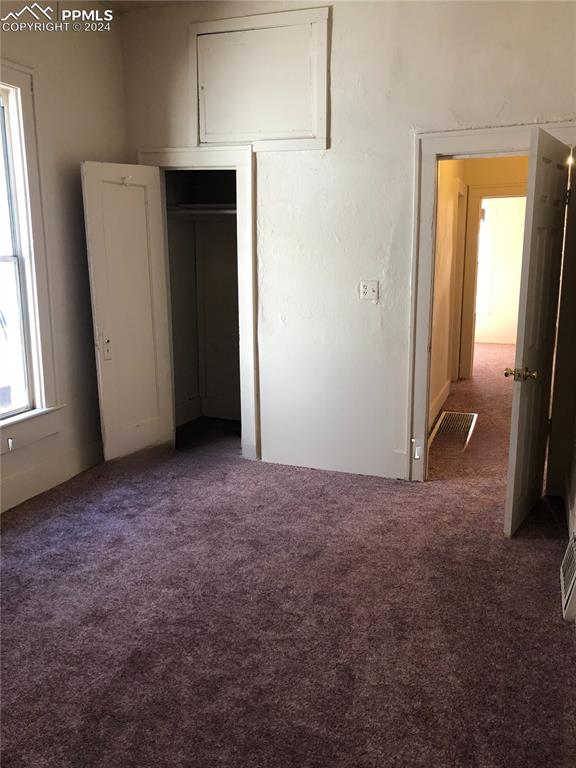 unfurnished bedroom with dark colored carpet