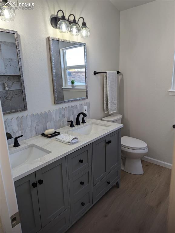 bathroom with hardwood / wood-style floors, vanity, and toilet