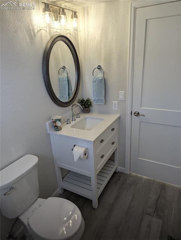 bathroom featuring hardwood / wood-style floors, vanity, and toilet