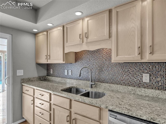 kitchen with light brown cabinetry, decorative backsplash, sink, and stainless steel dishwasher