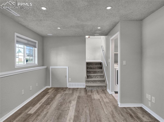 interior space with wood-type flooring and a textured ceiling