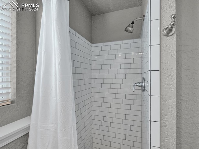 bathroom with a shower with curtain and a textured ceiling