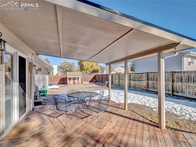 snow covered deck with an outbuilding