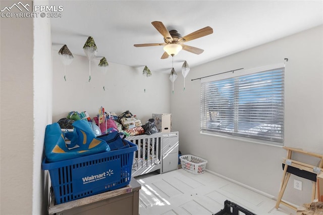 bedroom featuring ceiling fan and a nursery area