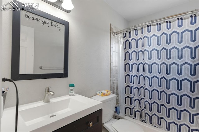 full bathroom with vanity, shower / tub combo, and toilet