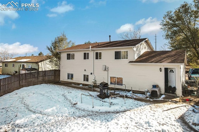 view of snow covered back of property