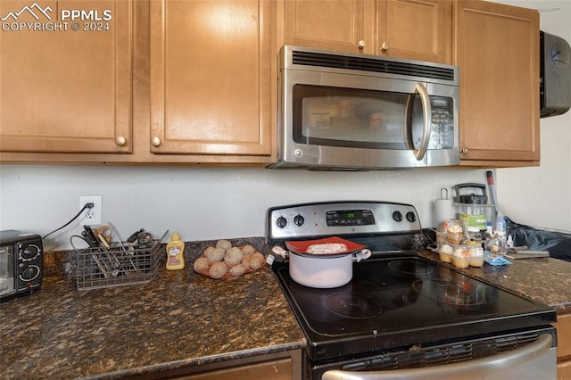 kitchen featuring appliances with stainless steel finishes and dark stone counters