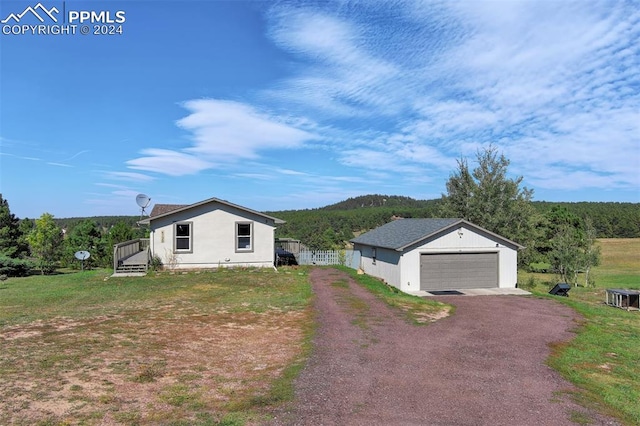 view of front of house with a front yard, an outdoor structure, and a garage