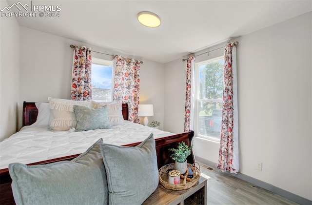 bedroom with multiple windows and wood-type flooring