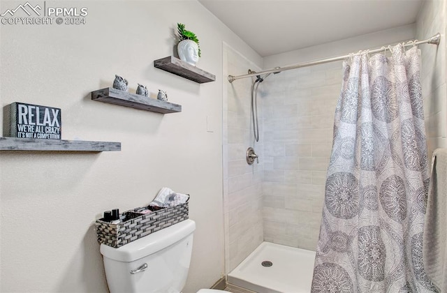 bathroom with curtained shower and toilet