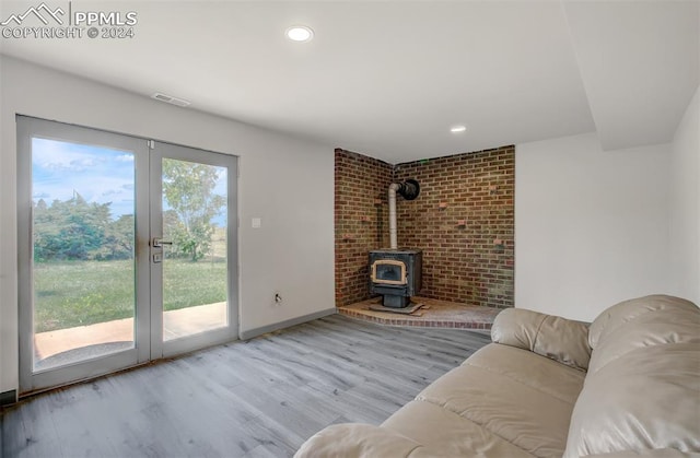 unfurnished living room with a wood stove, light hardwood / wood-style flooring, and plenty of natural light