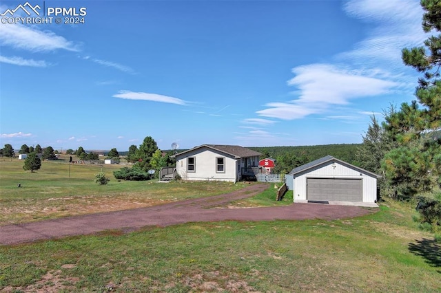 single story home featuring a garage, a front lawn, and an outdoor structure