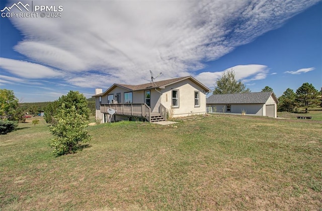 rear view of house with a yard and a deck