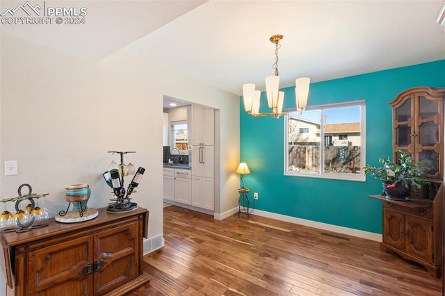 interior space with dark hardwood / wood-style flooring, an inviting chandelier, and plenty of natural light