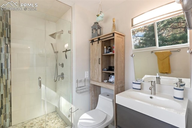 bathroom with vanity, toilet, and a shower with door