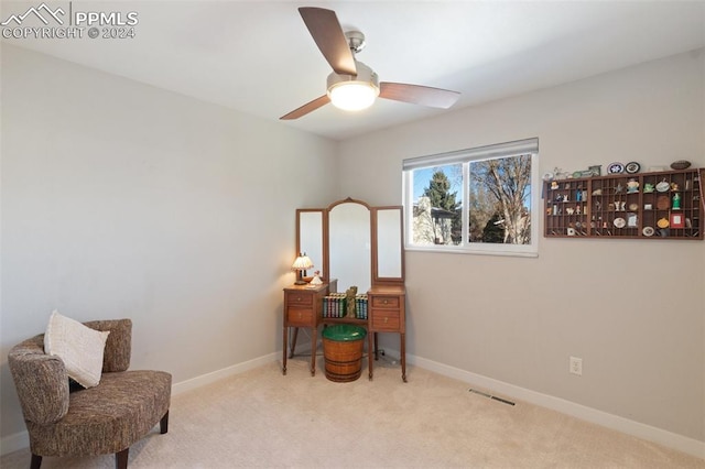 living area with light colored carpet and ceiling fan