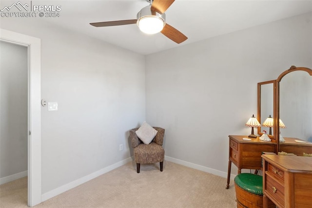 living area featuring ceiling fan and light colored carpet