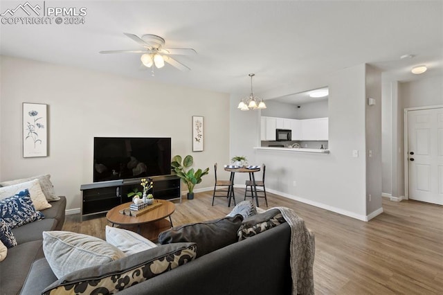 living room featuring ceiling fan with notable chandelier and wood-type flooring