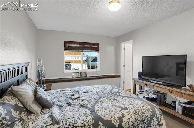 bedroom featuring hardwood / wood-style floors and a textured ceiling