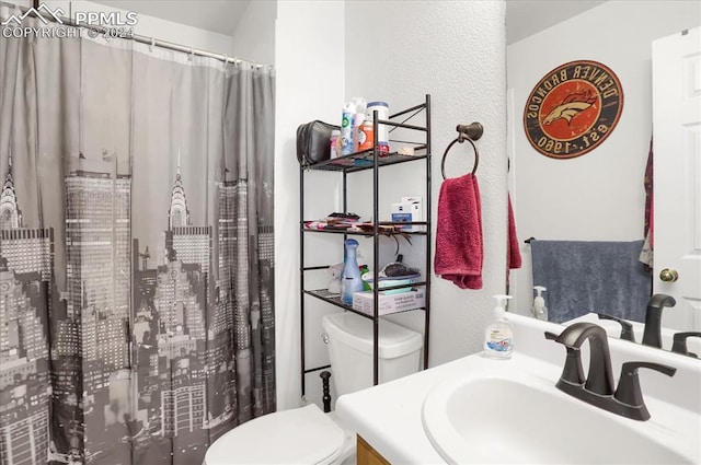 bathroom featuring a shower with shower curtain, vanity, and toilet