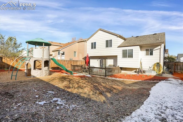 back of property featuring a playground