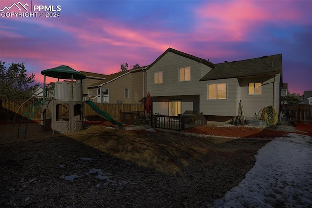 back house at dusk with a playground