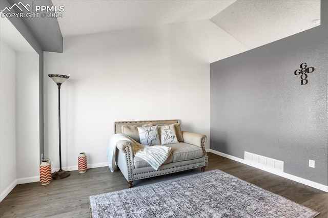 living area featuring dark wood-type flooring and vaulted ceiling