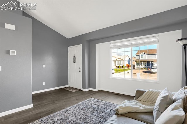 interior space with dark hardwood / wood-style floors and vaulted ceiling