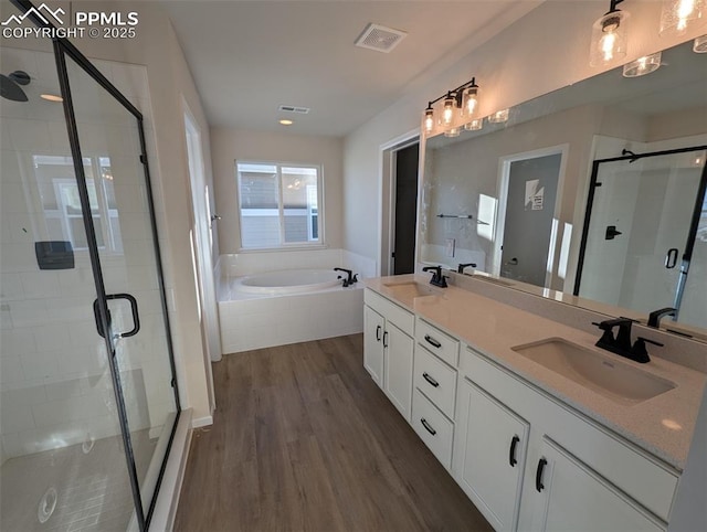 bathroom featuring vanity, wood-type flooring, and shower with separate bathtub