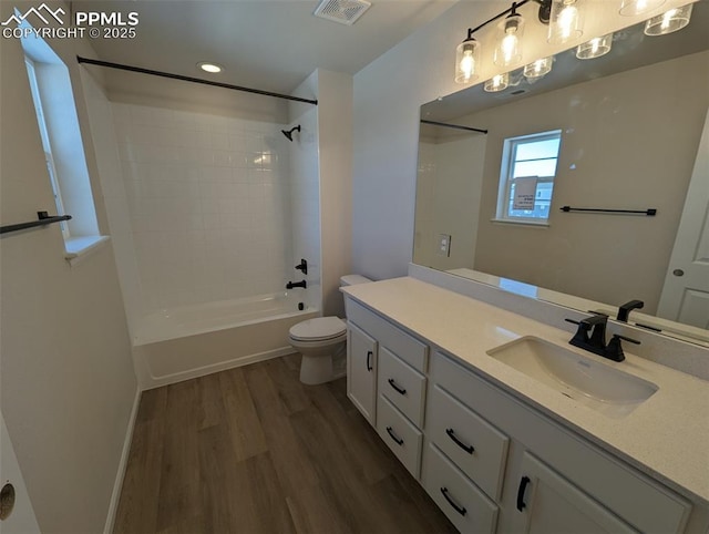 full bathroom featuring washtub / shower combination, toilet, wood-type flooring, and vanity