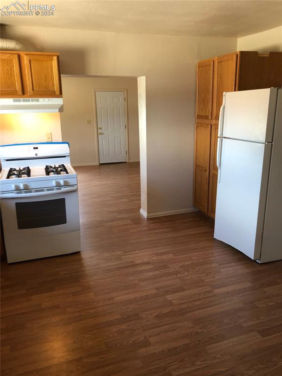 kitchen featuring dark hardwood / wood-style flooring and white appliances