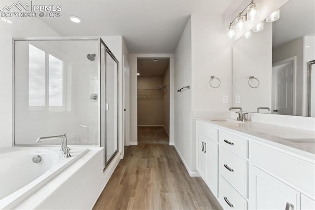 bathroom with shower with separate bathtub, hardwood / wood-style floors, and vanity