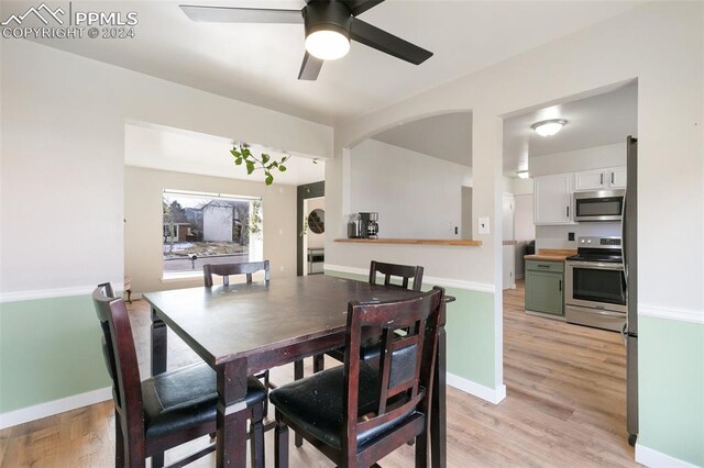 dining space with ceiling fan and light hardwood / wood-style flooring