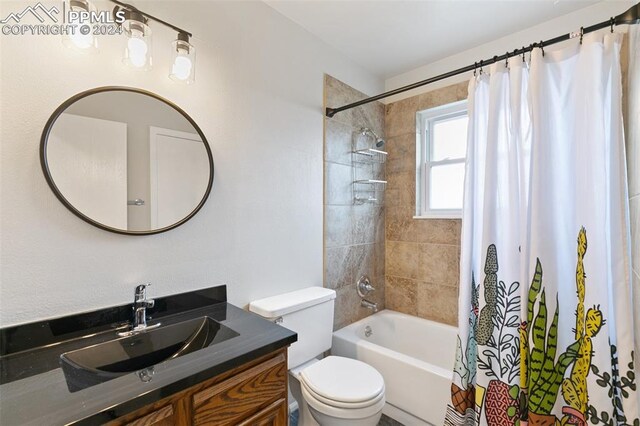 full bathroom with shower / tub combo with curtain, vanity, and toilet