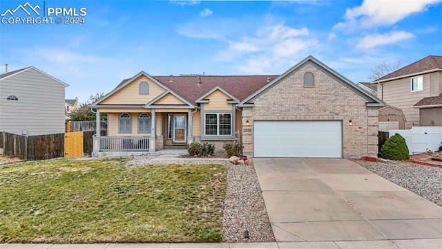 view of front of property with covered porch, a garage, and a front yard