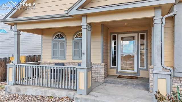 view of exterior entry featuring covered porch